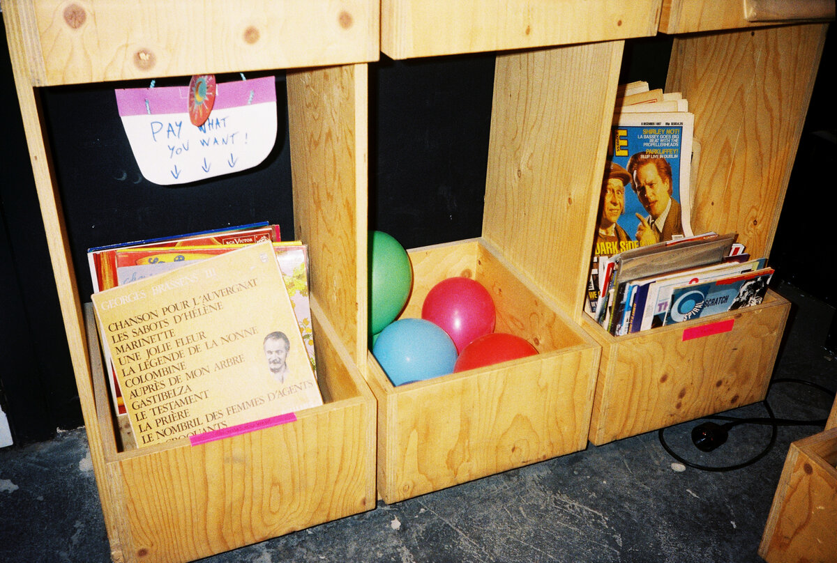 Balloons floating above a 'Pay What You Want' crate at 72records