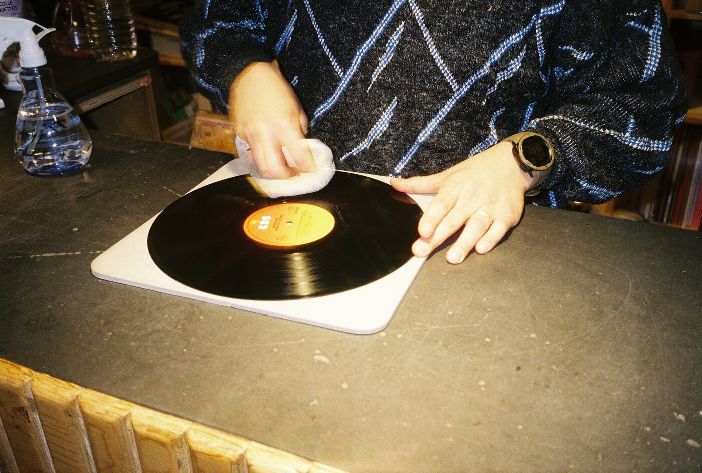 Hands cleaning a vinyl record