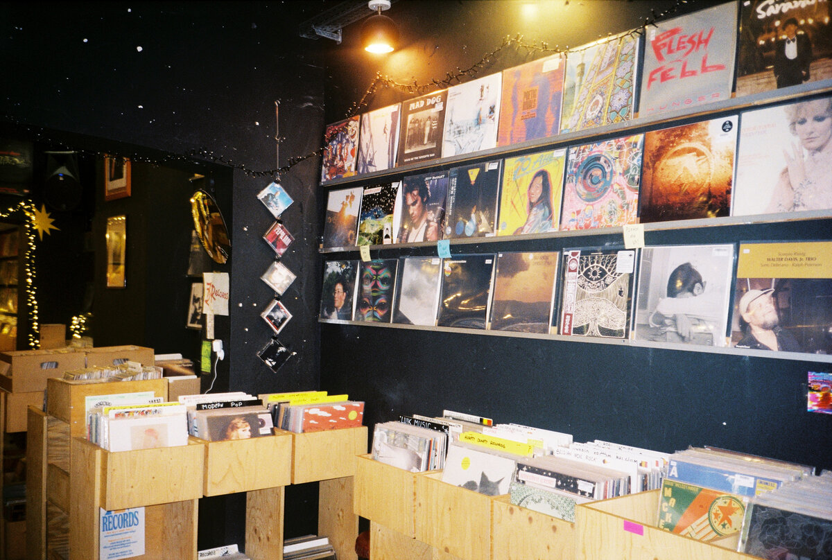 Wall of curated records at 72records, lit by fairy lights